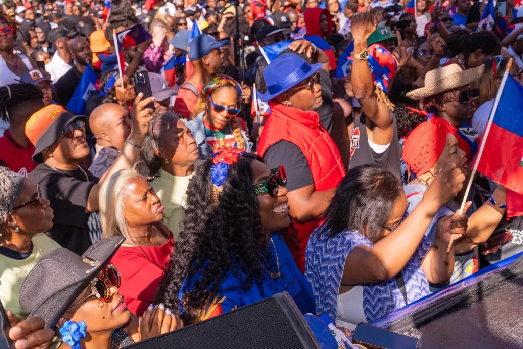 Audience members delight in front-row views of Miami-based T-Vice performing live at the Life of Hope Haitian Culture Day event at Hillel Place Plaza, Brooklyn, on May 10, 2025. Photo by Allison Hunter for The Haitian Times.