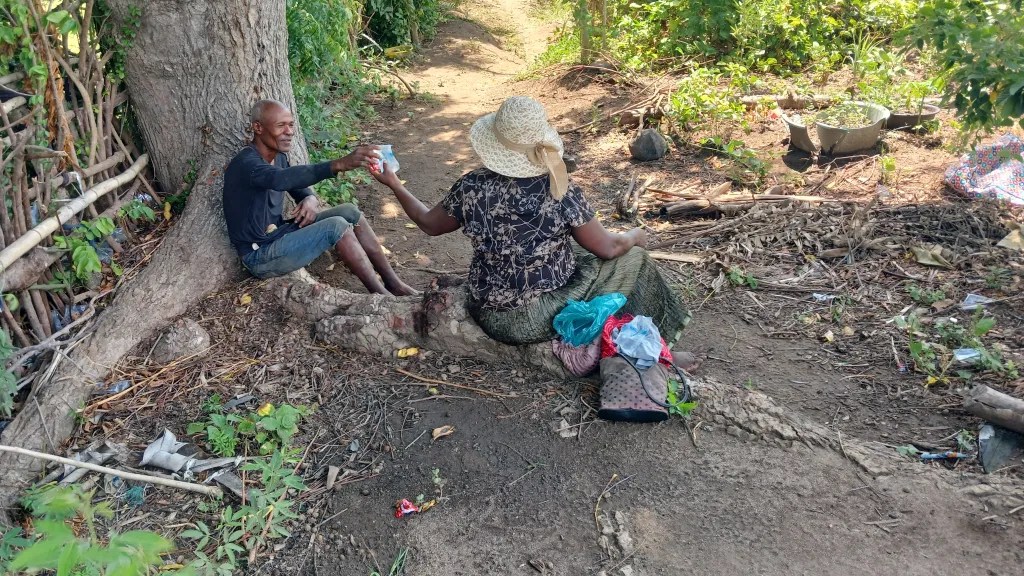 Marianne and her neighbor, Fanius Augustion, share food during their lunch break on June 24, 2025. Photo by Edxon Francisque/The Haitian Times