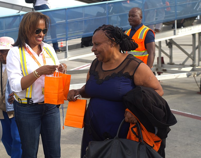 Passengers receive gift bags containing a keychain, candy and a miniature straw hat. Photo by Onz Chéry/The Haitian Times.